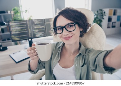 Photo of attractive happy lady sitting chair make selfie hold hot coffee cup enjoy office workplace indoors - Powered by Shutterstock