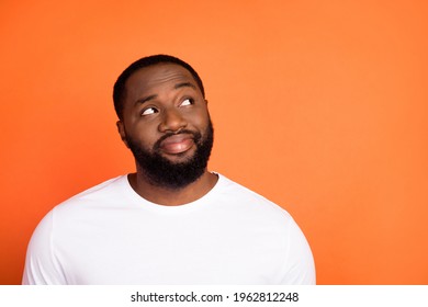 Photo of attractive happy young afro american man look empty space dream isolated on orange color background