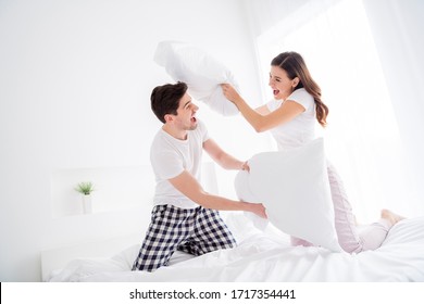 Photo of attractive lady cheer handsome guy married couple in love playing pillow fight sheets bed enjoy weekend saturday morning good excited mood wear pajama room indoors - Powered by Shutterstock