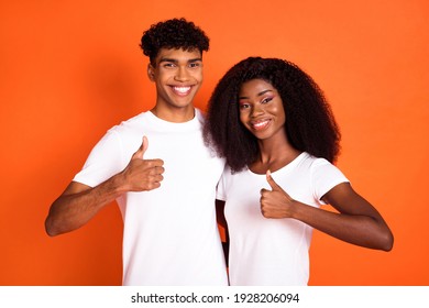 Photo of attractive lady handsome dark skin guy hug show thumbs up isolated on orange color background