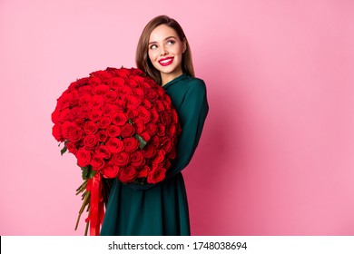 Photo of attractive lady red bright lipstick hold large roses bouquet boyfriend present look side empty space interested wear green dress isolated pastel pink color background