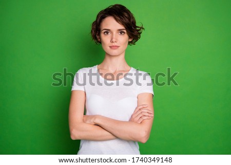 Photo of attractive lady short wavy hairdo arms crossed strict bossy person not smiling intelligent wear casual white t-shirt isolated green color background