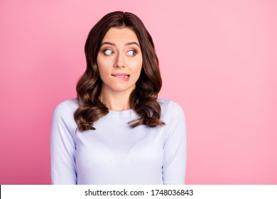 Photo of attractive lady wavy hairdo biting lips look shy side empty space made wrong bad thing uncomfortable situation wear casual white pullover isolated pink color background