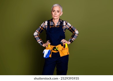 Photo of attractive mature woman professional mechanic confident pose dressed blue workwear overall isolated on khaki color background - Powered by Shutterstock