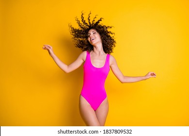 Photo of attractive overjoyed lady pleasant sun rays exotic resort eyes closed wavy hairdo flight warm breeze relaxation wear pink swimsuit isolated bright vivid shine yellow color background