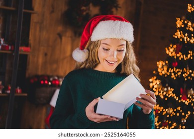 Photo of attractive teen girl open gift box dressed green christmas outfit cozy day light home party decoration interior living room - Powered by Shutterstock