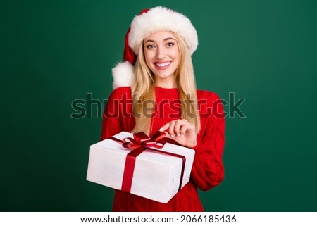 Photo of attractive young happy woman hold hands present box smile holiday isolated on green color background