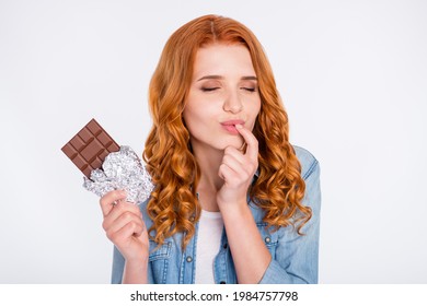 Photo Of Attractive Young Positive Nice Woman Hold Hand Chocolate Lick Finger Tasty Isolated On Grey Color Background