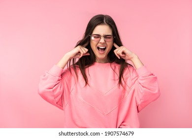 Photo Of Attractive Young Woman In Glasses Too Noisy Scream. Wears Casual Pink T-shirt White Pants Isolated Pink Color Background