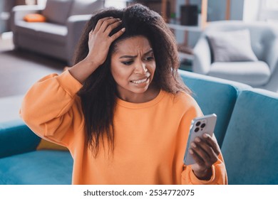 Photo of attractive young woman sit couch annoyed video call worried scared dressed orange outfit cozy day light home interior living room - Powered by Shutterstock