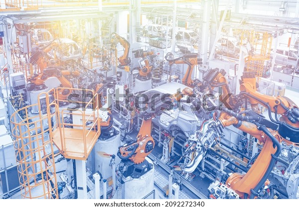 Photo of\
automobile production line. Welding car body. Modern car assembly\
plant. Top view in blue and yellow\
tone