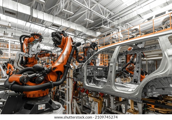 Photo of automobile production line.\
Welding car body. Modern car assembly plant. Auto industry.\
Interior of a high-tech factory, modern\
production