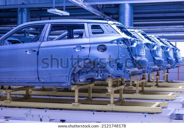 Photo of automobile production line. Welding car\
body. Modern car assembly plant. Auto industry. High-tech factory.\
Blue tone