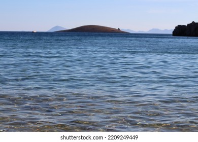 photo of azure sea, azure sky and nearby sloping islands photographed at noon in daylight