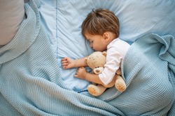 Fotografie De Băiat Copil Dormit împreună Cu Ursuleț De Pluș. Locul Lui Preferat De Dormit. Adorabil Băiat Copil După Dormit în Pat Cu Jucărie. Băiatul Doarme în Pat Cu Ursuleţ De Pluş. Somnorosule