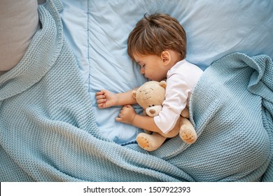 Photo of baby boy sleeping together with teddy bear. His favorite napping spot. Adorable kid boy after sleeping in bed with toy. Boy sleeping on bed with teddy bear. Sleepyhead - Powered by Shutterstock