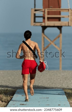 photo back view lifeguard running on beach