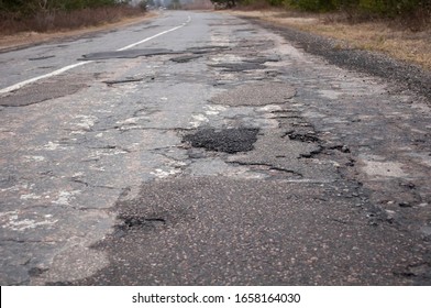 photo of a bad road, destroyed gray tarmac,  closeup