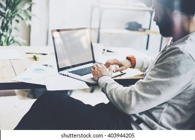 Photo Bearded Project Manager Working New Startup Modern Loft. Using Contemprary Laptop With Reflections Screen On Wood Table. Creative Process. Blurred Background, Film Effect, Horizontal