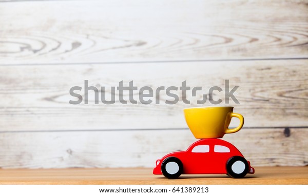 photo of beautiful car shaped toy\
and cup of coffee on the wonderful white studio\
background