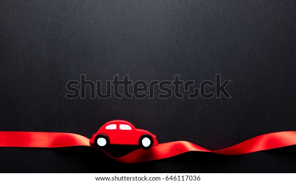 photo of beautiful car shaped toy and\
ribbon on the wonderful black studio\
background