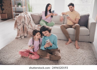 Photo of beautiful cute children dad mom dressed casual clothes communcating modern gadgets indoors house apartment room - Powered by Shutterstock