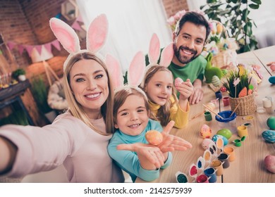 Photo of beautiful idyllic family four people take selfie showing painted eggs wear bunny ears home indoors