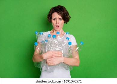 Photo of beautiful lady hold plastic bottles carry trash recycling reduce service shocked open mouth irresponsible people human beings wear white t-shirt isolated green color background
