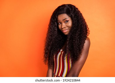Photo of beautiful lovely charming stunning african woman with long curly brunette hair isolated on orange color background