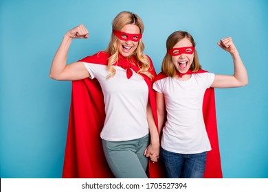 Photo of beautiful mom lady little daughter spend time together carnival super hero costumes showing strength muscles wear s-shirts red coat masks isolated blue color background