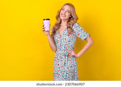Photo of beautiful young lady wavy blonde hair hold cup tasty takeaway cacao look empty space coffee shop isolated on yellow background