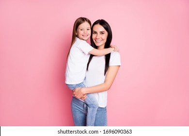 Photo of beautiful young mother hold arms little daughter two ladies hugging good mood best friends wear casual white t-shirts jeans isolated pastel pink color background - Powered by Shutterstock