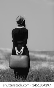 photo of the beautiful young woman with suitcase in the field