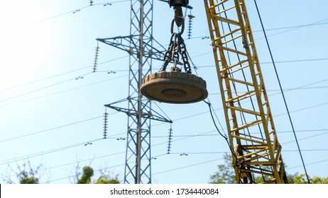 Photo of big electric magnet hanging on crane on the dump