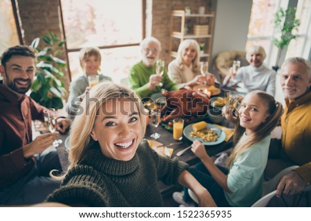Photo of big family sit feast dishes table around roasted turkey multi-generation relatives making group selfies raising wine glasses juice in living room indoors