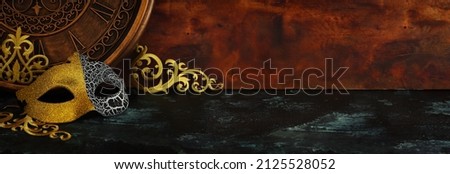 Photo of black with gold elegant Venetian mask over grunge background