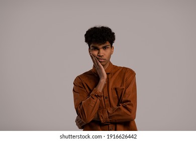 Photo Of Black Man Looks Bored And Not Interested In Something. Male Wears Shirt, Isolated Grey Color Background