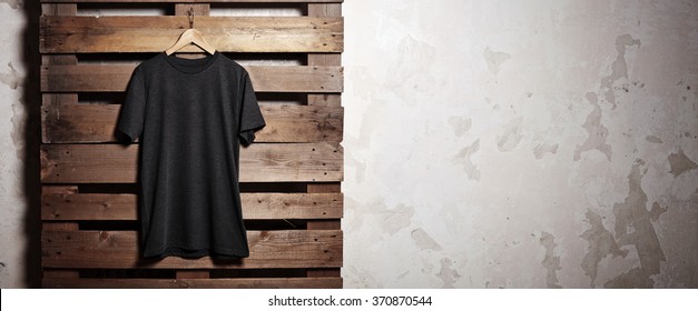 Photo Black Tshirt  Hanging In Front Of Wood Background. Wide