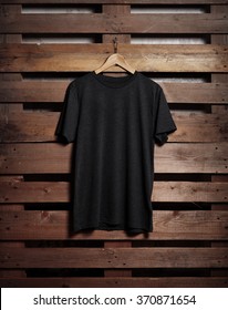 Photo Of Black Tshirt Holding On Wood Background