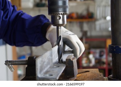 
Photo of a blacksmith in his workshop while making holes with a pillar drill on an iron bar for the construction of a railing. Manual and do-it-yourself jobs - Powered by Shutterstock