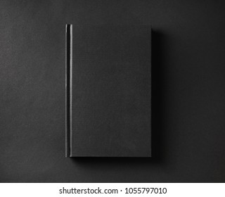 Photo Of Blank Black Book Cover On Black Paper Background. Flat Lay.