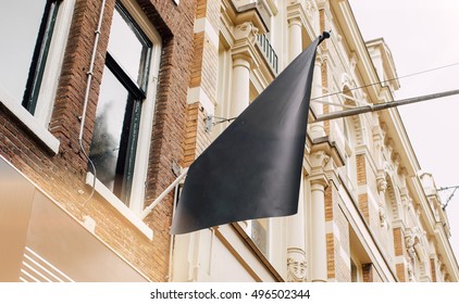 Photo Blank Black Flag On The Street. Black Signboard On The Vintage Brick Wall. Mock Up.