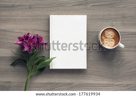 Photo blank book cover on textured wood background with spring flower and cape of coffee