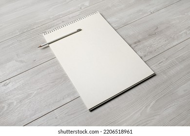 Photo of blank notepad and pencil on light wooden background. Responsive design template.