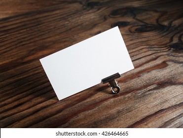 Photo of blank white business card on wooden table background. Template for branding identity.