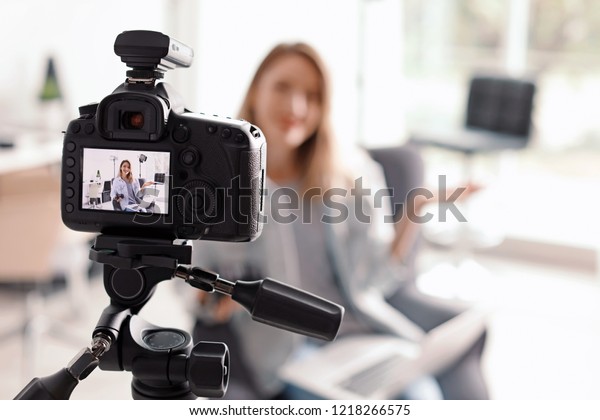 Photo blogger recording video indoors,
selective focus on camera display. Space for
text