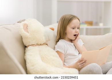 Photo Of Blond Girl Reading A Book To Her Toy Plush Friend.