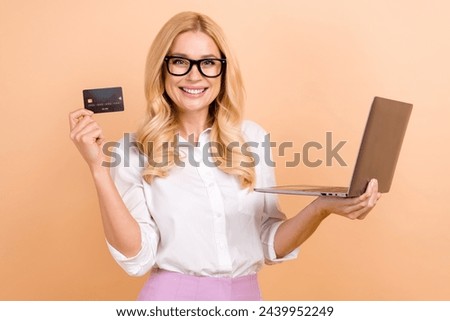 Photo of blond hair businesswoman specialist in ecommerce recommend using mastercard payment hold laptop isolated on beige color background