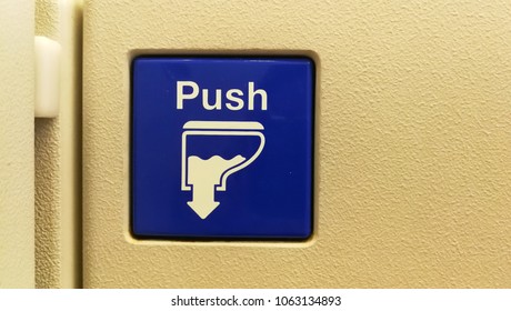 A Photo Of Blue Sign PUSH For The Lavatory On The Airplane. Blue Flush Button.