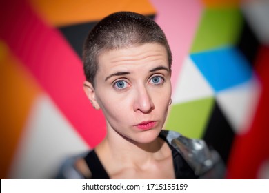 Photo with Blur effect. Close-up portrait of young emotional woman with short hair on bright geometric background. 